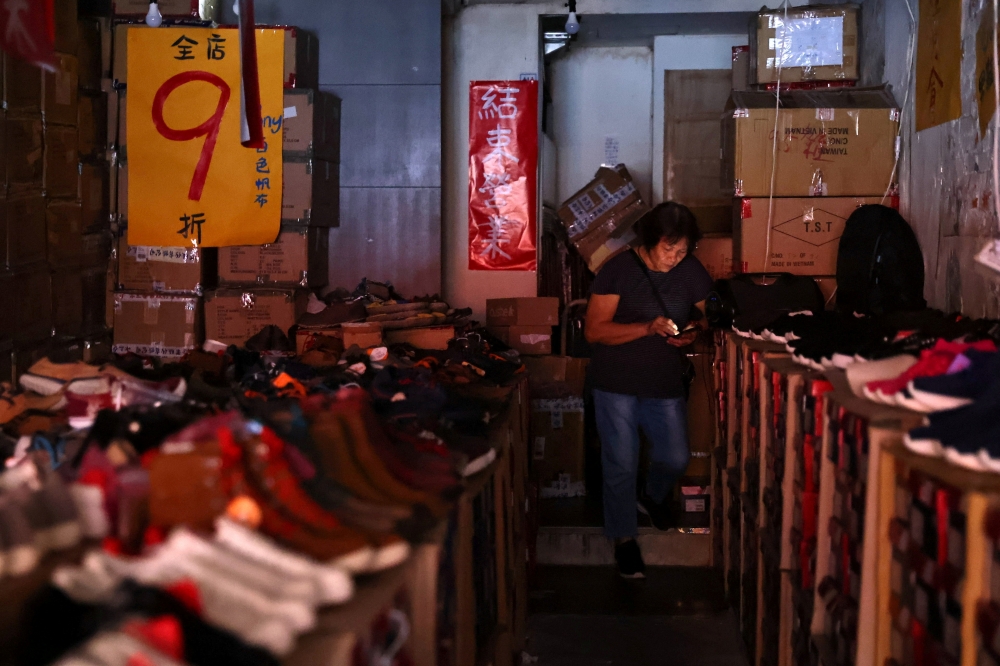 A woman uses her phone while experiencing a blackout due to an outage at a power plant, in Taipei, Taiwan, May 13, 2021. REUTER/Ann Wang/File Photo