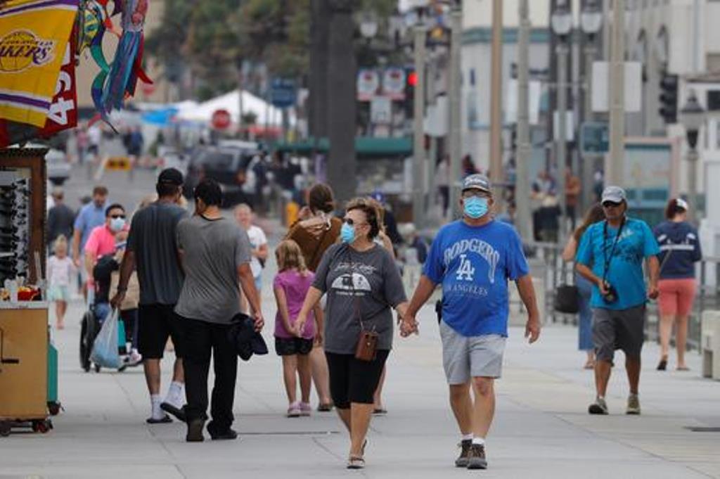 FILE PHOTO: People wearing face masks walk along the ocean pier in Huntington Beach, California, U.S., July 23, 2020. REUTERS/Mike... MIKE BLAKE July 28, 2020
