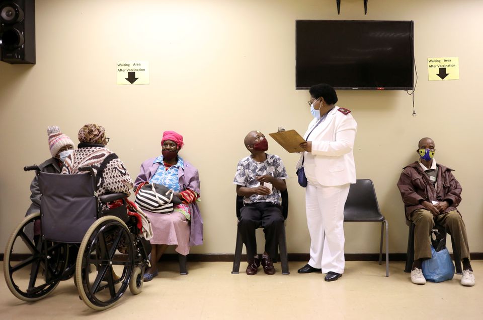 A nurse talks to a man following his vaccination, as South Africa rolls out the coronavirus disease (COVID-19) vaccines to the elderly at the Munsieville Care for the Aged Centre outside Johannesburg, South Africa May 17, 2021. REUTERS/Siphiwe Sibeko/File