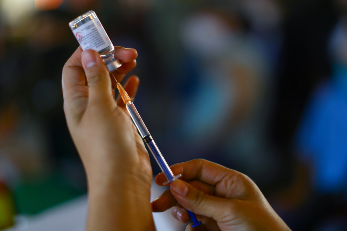 A health worker prepares to vaccinate a school worker with a dose of China's CanSino COVID-19 vaccine during a mass vaccination for teachers and school staff against coronavirus disease in Mexico City, Mexico May 18, 2021. REUTERS/Edgard Garrido
