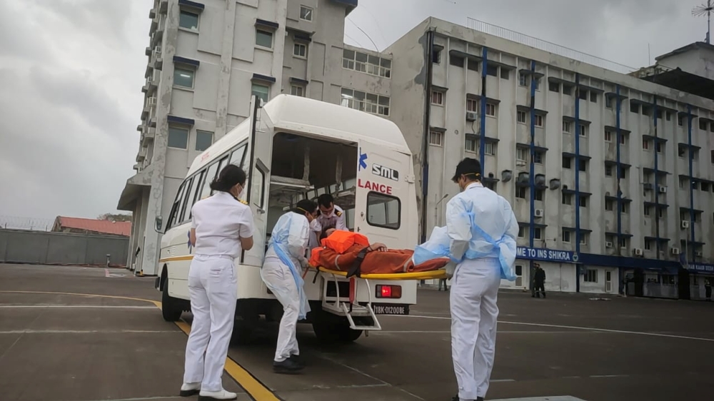 Members of the Indian Navy transport a person to receive medical attention after a rescue from a sunken barge in the Arabian Sea in the aftermath of cyclone Tauktae's landfall, at naval air station INS Shikra in Mumbai, May 18, 2021. Indian Navy/Handout v