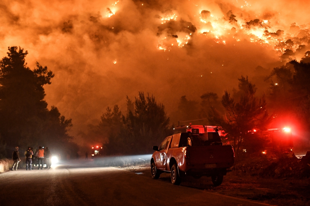 Flames rise as firefighters and volunteers try to extinguish a fire burning in the village of Schinos, near Corinth, Greece, May 19, 2021. Picture taken May 19, 2021. REUTERS/Vassilis Psomas