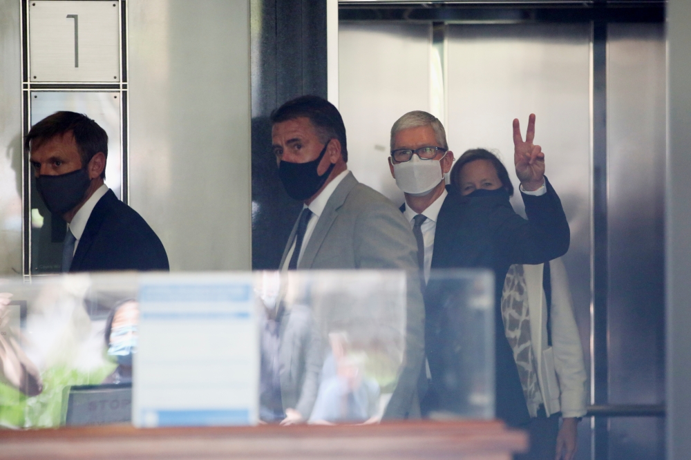 Apple CEO Tim Cook gestures from the elevator as he leaves after speaking during a weeks-long antitrust trial at federal court in Oakland, California, U.S. May 21, 2021. Reuters/Brittany Hosea-Small
