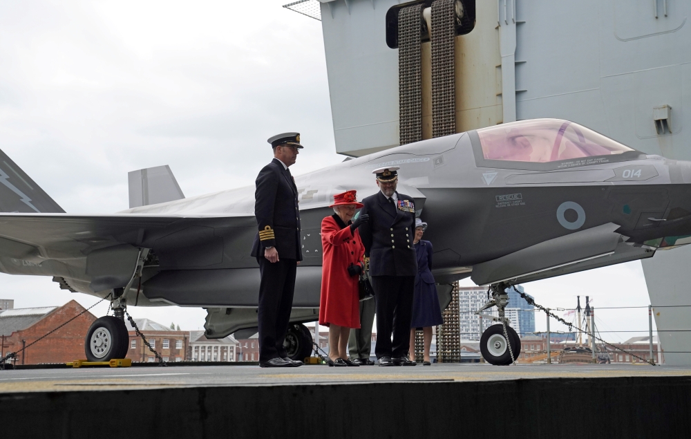 Captain Angus Essenhigh and Commodore Steve Moorhouse are seen with Britain's Queen Elizabeth during Her visit to the Royal Navy aircraft carrier HMS Queen Elizabeth at HM Naval Base in Portsmouth, Britain May 22, 2021. Steve Parsons/PA Wire/Pool via REUT