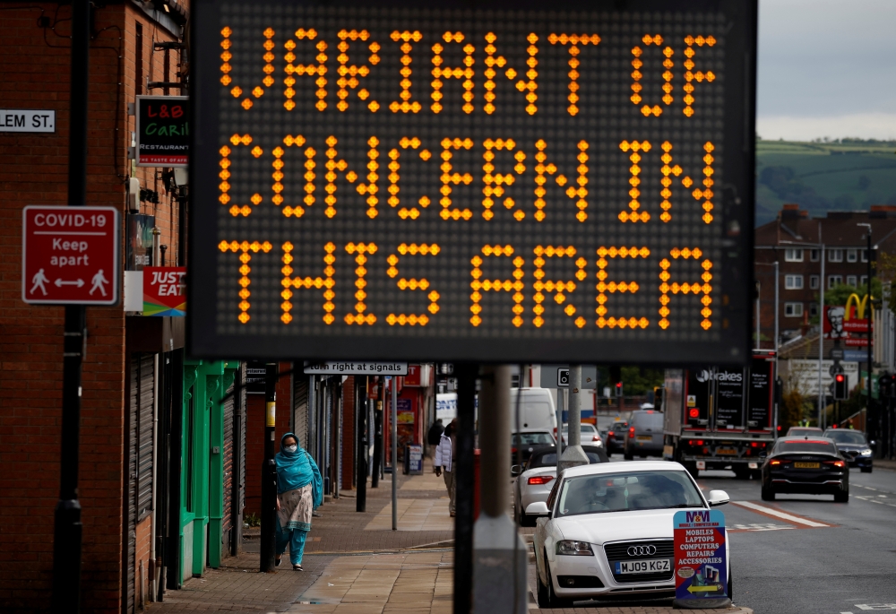 FILE PHOTO: A woman walks past an information sign amid the outbreak of the coronavirus disease (COVID-19) in Bolton, Britain, May 17, 2021. REUTERS/Phil Noble/File Photo
 