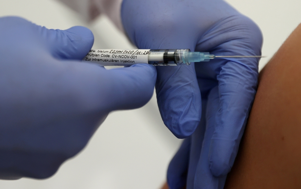 File photo: Professor Gottfried Kremsner injects a vaccination against the coronavirus disease (COVID-19) from German biotechnology company CureVac to a volunteer at the start of a clinical test series at his tropical institute of the university clinic in