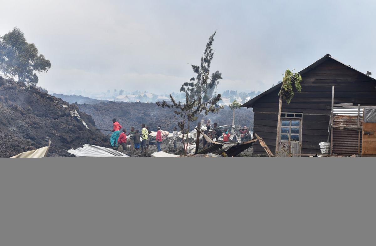 Residents pick up remains of their destroyed homes from the smouldering lava deposited by the eruption of Mount Nyiragongo volcano near Goma, in the Democratic Republic of Congo May 23, 2021. REUTERS/Olivia Acland

