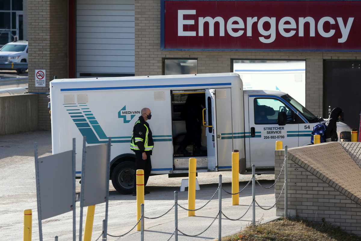 FILE PHOTO: A health care worker in a surgical mask helps unload a stretcher service vehicle at St. Boniface Hospital in Winnipeg, Manitoba, Canada, November 1, 2020. REUTERS/Shannon VanRaes/File Photo
