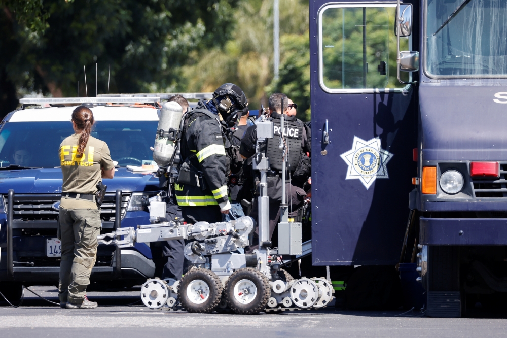 San Jose Bomb Squad technician prepares to enter the scene of the Santa Clara Valley Transportation Authority mass shooting suspects house that was set ablaze in San Jose, California, U.S. May 26, 2021. REUTERS/Peter DaSilva
