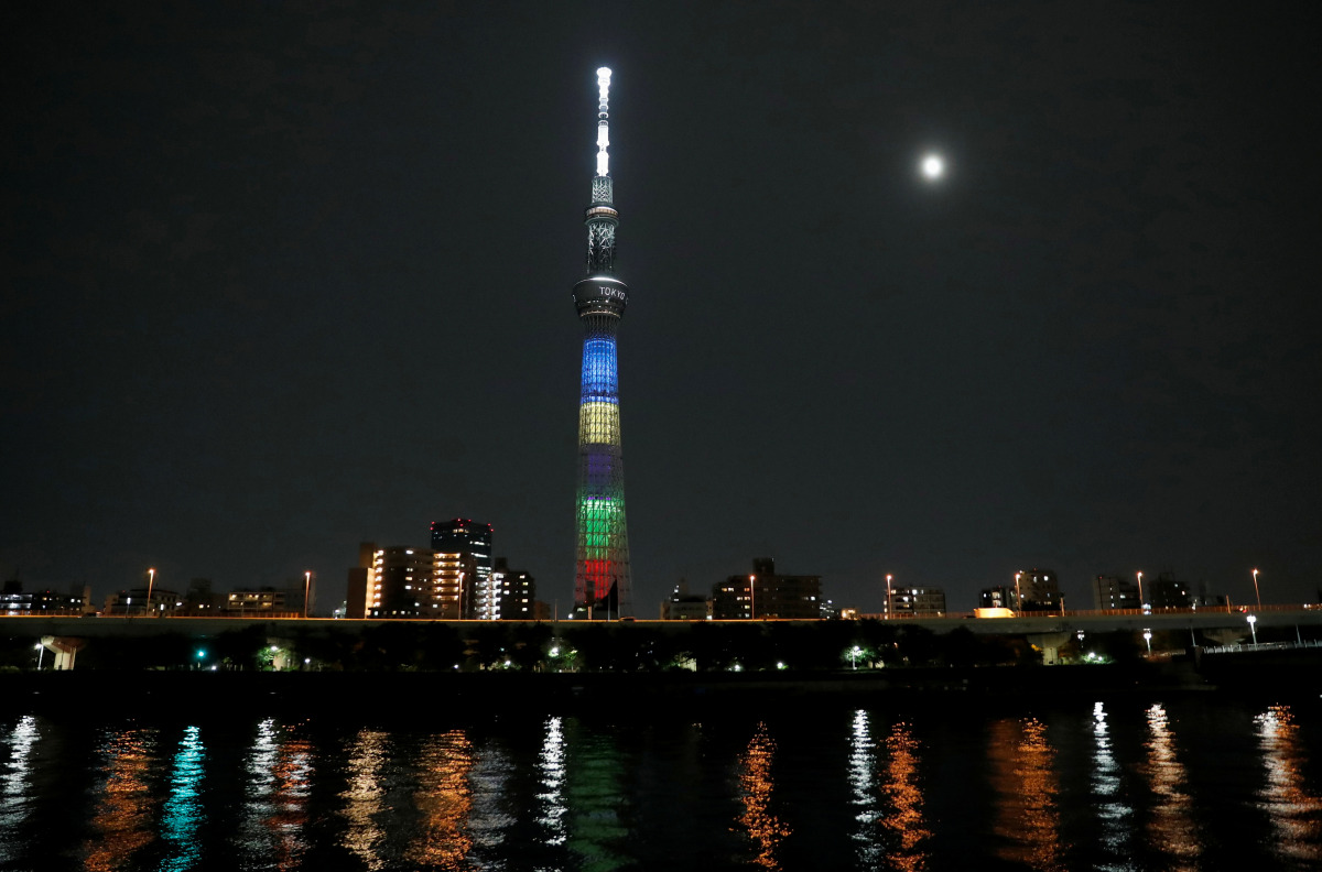 A supermoon, the biggest and brightest full moon of the year, shines next to the Tokyo Skytree which is illuminated with colors of the Tokyo 2020 Olympic Games, in Tokyo, Japan May 26, 2021. REUTERS/Issei Kato
