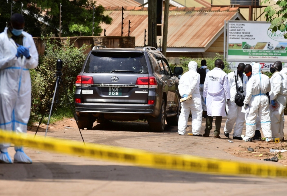 Forensic experts secure the scene of an attempted assassination on Ugandan minister of works and transport General Katumba Wamala, in which he was wounded and his daughter and driver killed, an army spokeswoman and local media reports said, in the suburb 