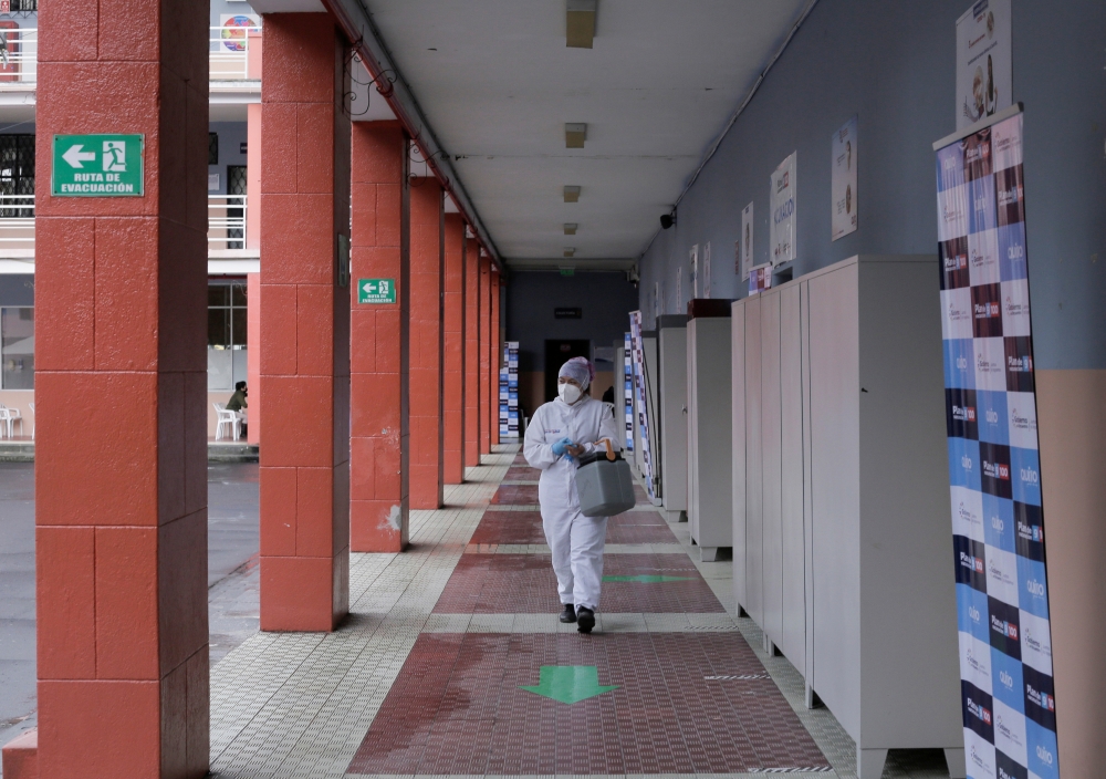 A healthcare worker carries a cooler with vials of vaccines against the coronavirus disease (COVID-19) at a school turned vaccination centre as Ecuador's government launched a plan to vaccinate nine million people in 100 days, in Quito, Ecuador June 1, 20