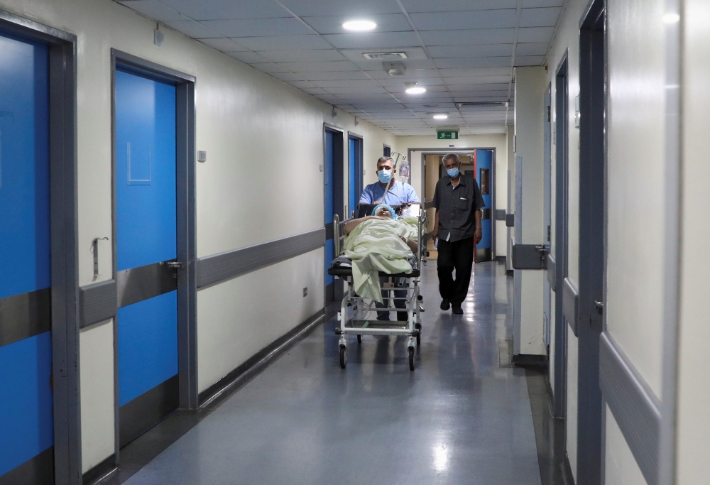 A healthcare worker wheels a patient inside a hospital in Beirut, Lebanon May 31, 2021. Reuters/Mohamed Azakir