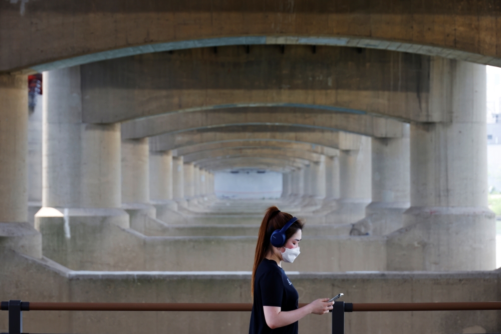 A woman takes a walk at a Han river park amid the coronavirus disease (COVID-19) pandemic, in Seoul, South Korea, June 2, 2021. REUTERS/Kim Hong-Ji