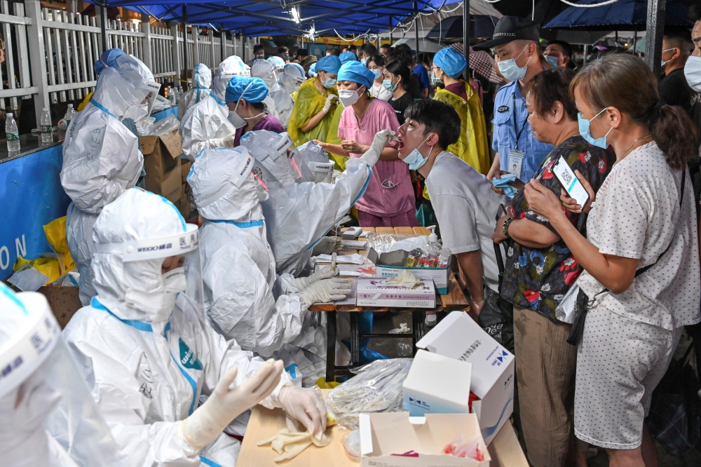 A medical worker collects a swab from a resident during a mass testing for the coronavirus disease (COVID-19) at a makeshift testing site in Guangzhou, Guangdong province, China May 30, 2021. Picture taken May 30, 2021. cnsphoto via REUTERS