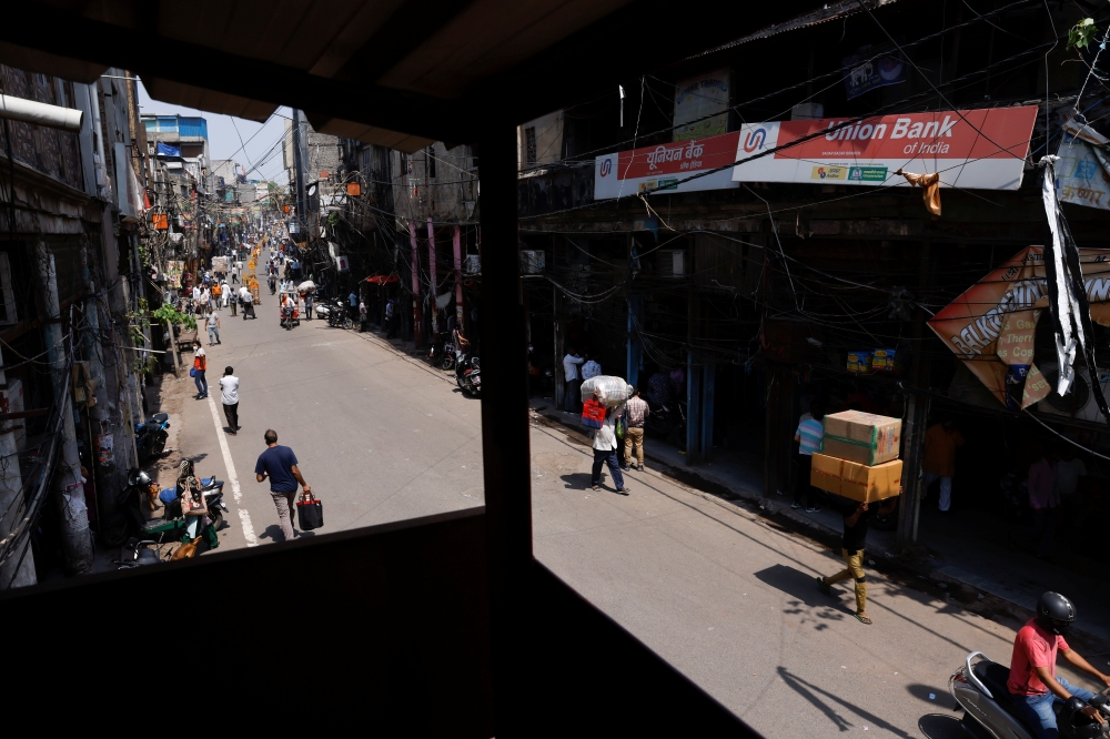 Workers carry goods at a market area after authorities eased lockdown restrictions that were imposed to slow down the spread of the coronavirus disease (COVID-19), in New Delhi, India, June 7, 2021. REUTERS/Adnan Abidi