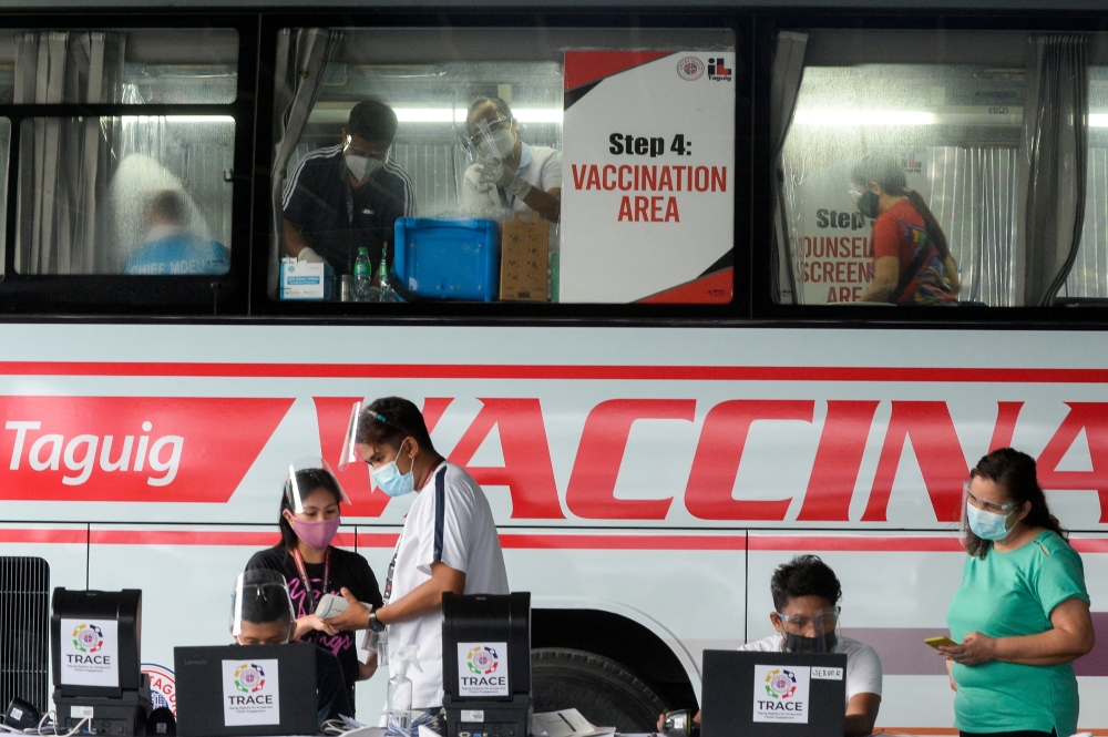 Health workers encode information and prepare vaccines against the coronavirus disease (COVID-19) at a mobile vaccination site in Taguig, Metro Manila, Philippines, May 21, 2021. REUTERS/Lisa Marie David/File Photo