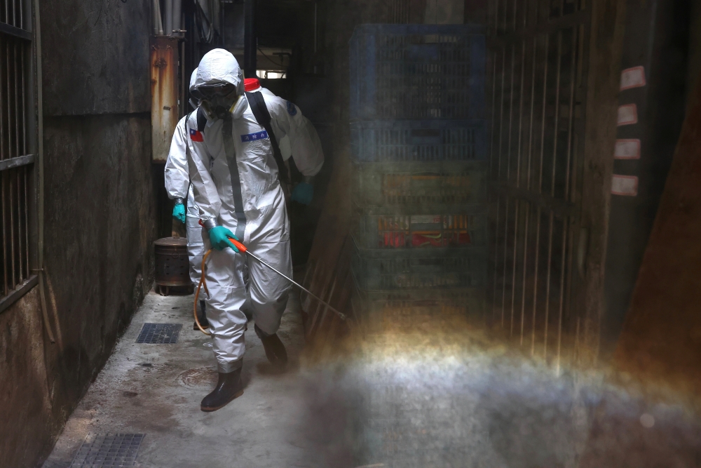 Soldiers in protective suits disinfect a street following the recent surge of coronavirus disease (COVID-19) infections, in the Tucheng district of New Taipei City, Taiwan May 27, 2021. REUTERS/Ann Wang/File Photo