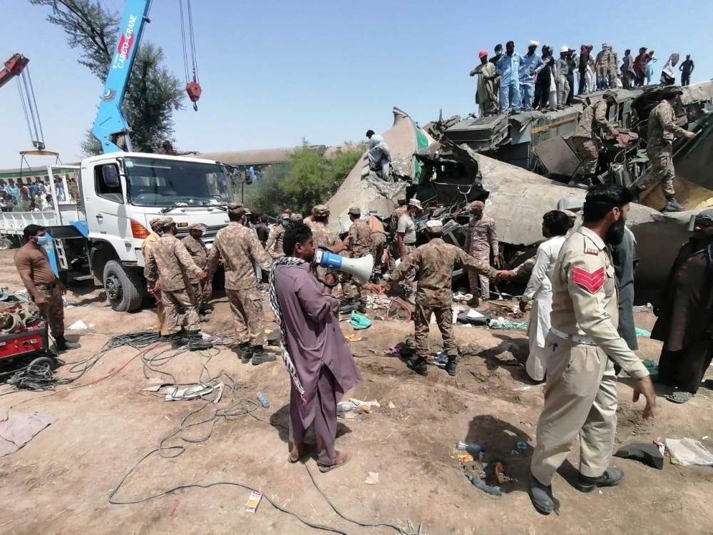 Paramilitary soldiers and rescue workers gather at the site following a collision between two trains in Ghotki, Pakistan June 7, 2021. Inter-Services Public Relations (ISPR)/ Handout via REUTERS