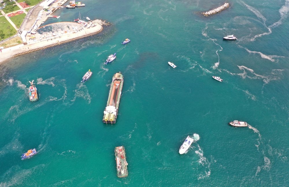 Aerial view of cleaning vessels and boats sailing through the sea covered with a plague of sea snot, a thick slimy layer of the organic matter also known as marine mucilage, spreading through the Sea of Marmara and posing a threat to marine life and the f