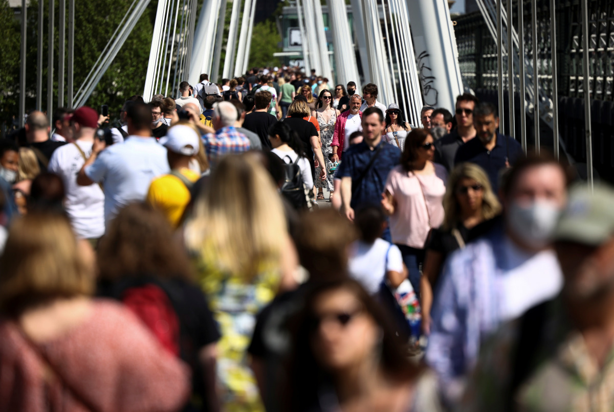 People walk across the Golden Jubilee Bridge during sunny weather, amid the coronavirus disease (COVID-19) outbreak, in London, Britain, June 5, 2021. REUTERS/Henry Nicholls
