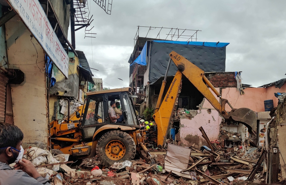 Rescue workers search for survivors in the debris after a residential building collapsed in Mumbai, India, June 10, 2021. REUTERS/Hemanshi Kamani