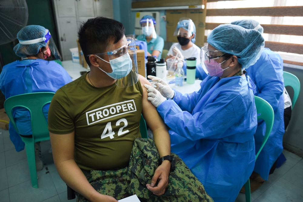 A police officer receives his first dose of Sinovac Biotech’s CoronaVac vaccine for the coronavirus disease (COVID-19) during the vaccination of essential workers, at the Navotas Fish Port, in Navotas City, Metro Manila, Philippines, June 10, 2021. REUTER