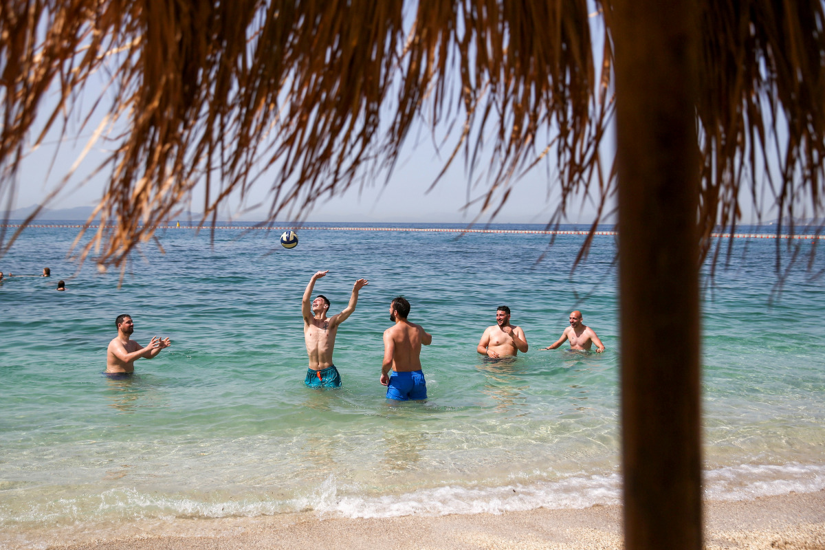 FILE PHOTO: People enjoy the sea during the official reopening of beaches to the public, following the easing of measures against the spread of the coronavirus disease (COVID-19), in Athens, Greece, May 8, 2021. REUTERS/Costas Baltas/File Photo
