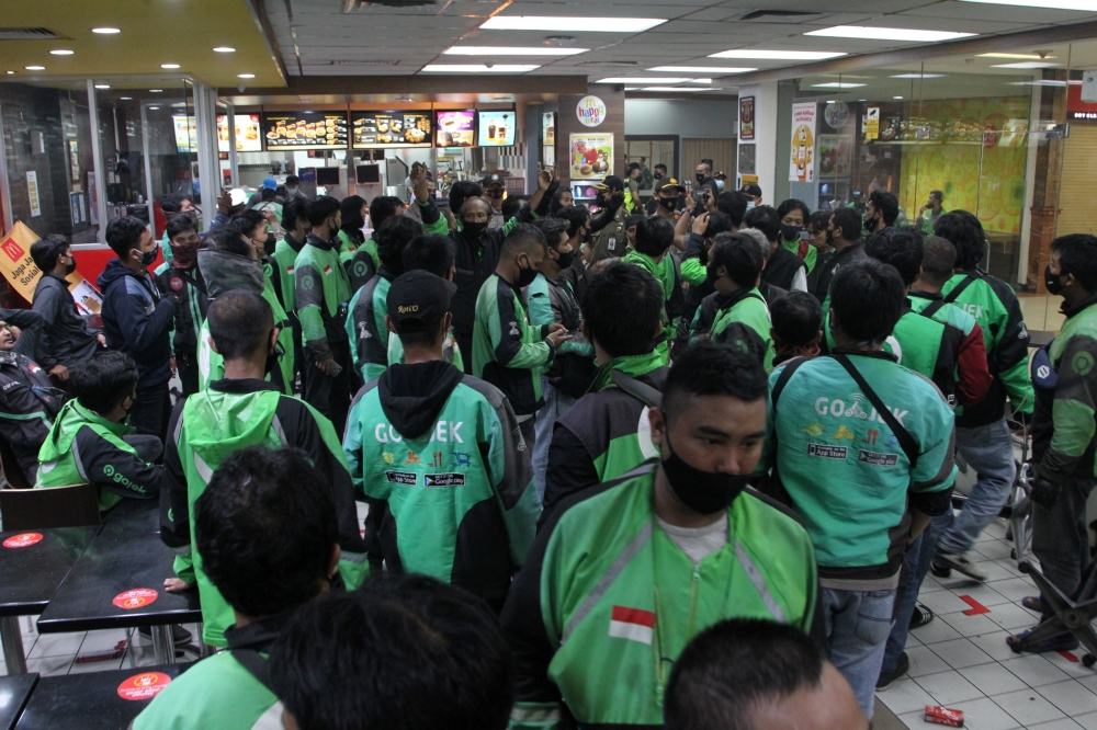 Food delivery drivers crowd in a McDonald's restaurant and wait for BTS meal orders in Bogor, Indonesia, June 9, 2021 in this picture obtained from social media. SOFYAN SHAH ? RADAR BOGOR/via REUTERS