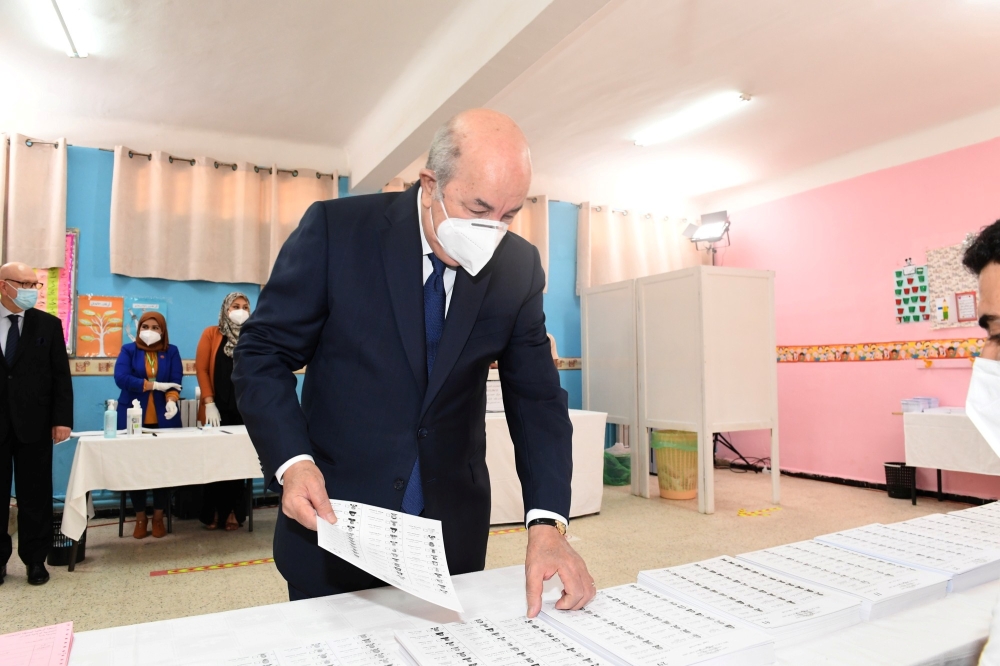 Algeria's President Abdelmadjid Tebboune prepares to cast his vote at a polling station during the country's parliamentary election in Bouchaoui, Algeria June 12, 2021. 
