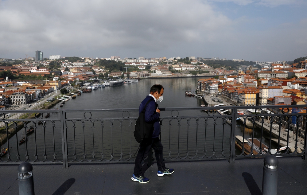 FILE PHOTO: A man walks on Dom Luis I Bridge in Porto ahead of the Champions League Final, May 28, 2021. REUTERS/Pedro Nunes