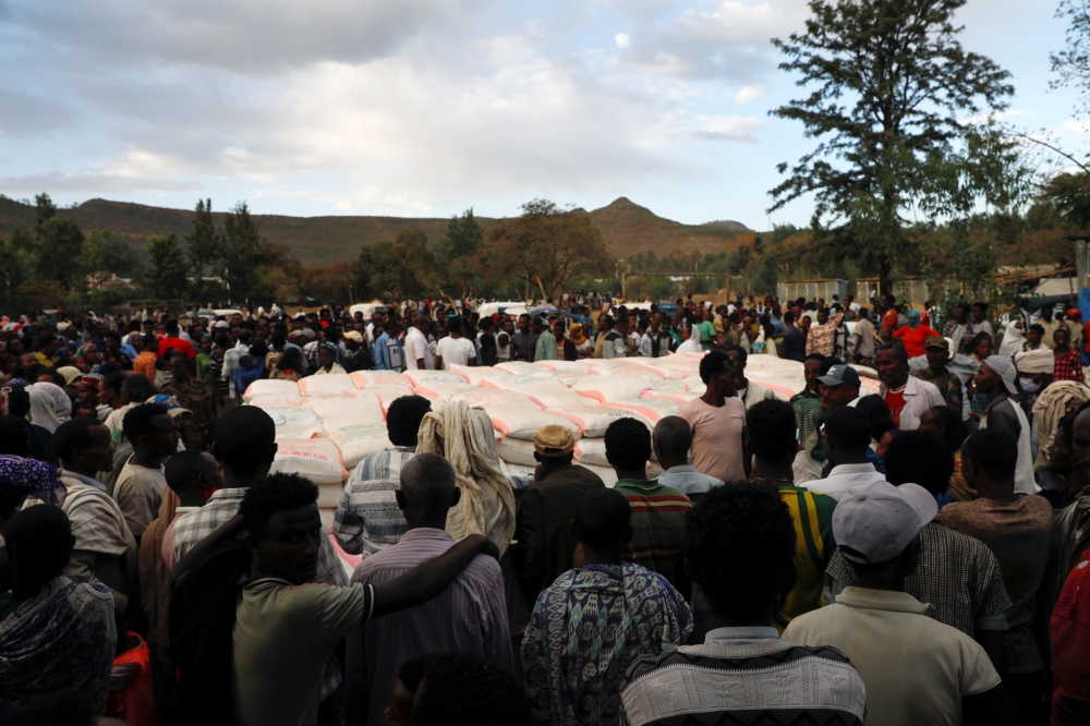 FILE PHOTO: People stand in line to receive food donations, at the Tsehaye primary school, which was turned into a temporary shelter for people displaced by conflict, in the town of Shire, Tigray region, Ethiopia, March 15, 2021. Picture taken March 15, 2