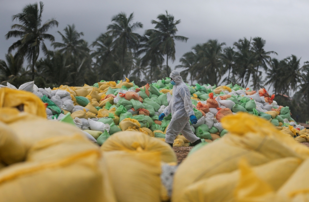 A Sri Lankan navy member walks past the sacks of collected debris washed to a beach from the MV X-Press Pearl container ship which caught fire and sunk off the Colombo Harbour, in Ja-Ela, Sri Lanka June 14, 2021. Reuters/Dinuka Liyanawatte