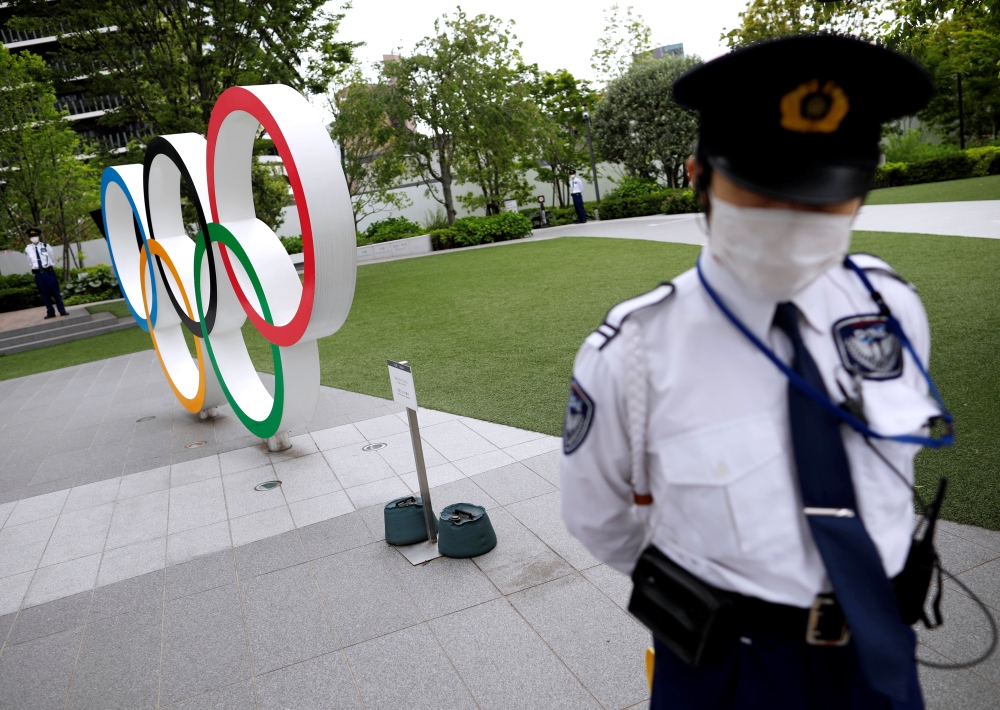 Security personnel stand guard near the Olympic rings monument outside the Japanese Olympic Committee headquarters. REUTERS/Issei Kato/File Photo