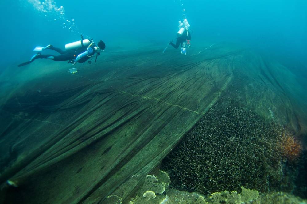 Abandoned fishing nets cover a coral reef in a protected area of Ko Losin, where a group of volunteer divers and the Coastal Resources Research Center, helped by the Royal Thai Navy, removed 2,750 sq m of them, Ko Losin, Thailand June 19, 2021. Picture ta