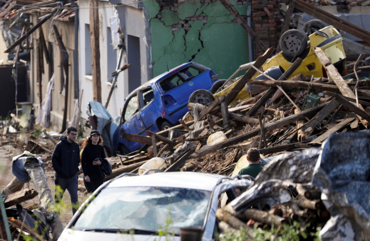 People walk among debris of damaged houses and cars in the aftermath of a rare tornado that struck and destroyed parts of some towns, in Mikulcice village, Czech Republic, June 25, 2021. REUTERS/David W Cerny
