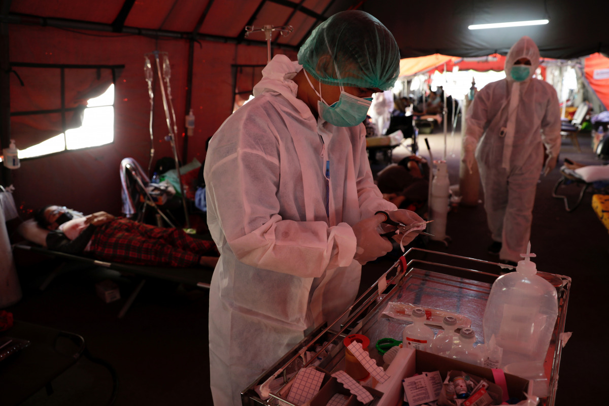 Healthcare workers prepare to assist COVID-19 patients at a temporary tent outside the emergency ward of a government hospital in Bekasi, on the outskirts of Jakarta, Indonesia, June 25, 2021. REUTERS/Willy Kurniawan
