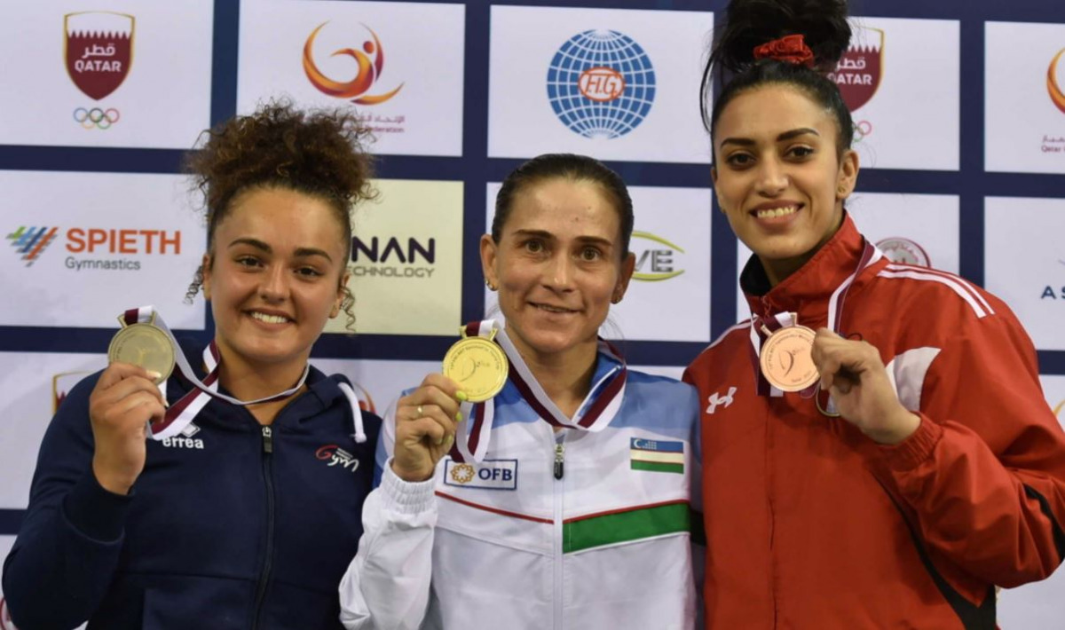 Oksana Chusovitina poses with her gold medal along with other gymnasts yesterday.
