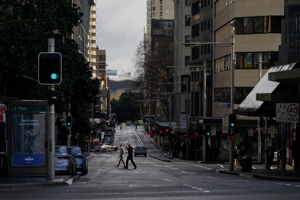 Pedestrians cross an unusually quiet street in the city centre during a lockdown to curb the spread of a coronavirus disease (COVID-19) outbreak in Sydney, Australia, June 29, 2021. REUTERS/Loren Elliott