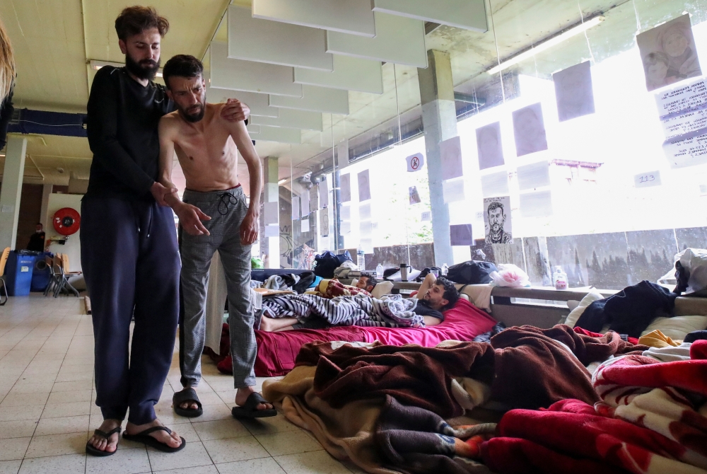 Youssef Bouzidi, a Moroccan asylum seeker, requesting to be regularised by the Belgian government to have access to healthcare, and who is going on hunger strike for more than a month, is helped by a person in a room on the campus of Belgium university UL