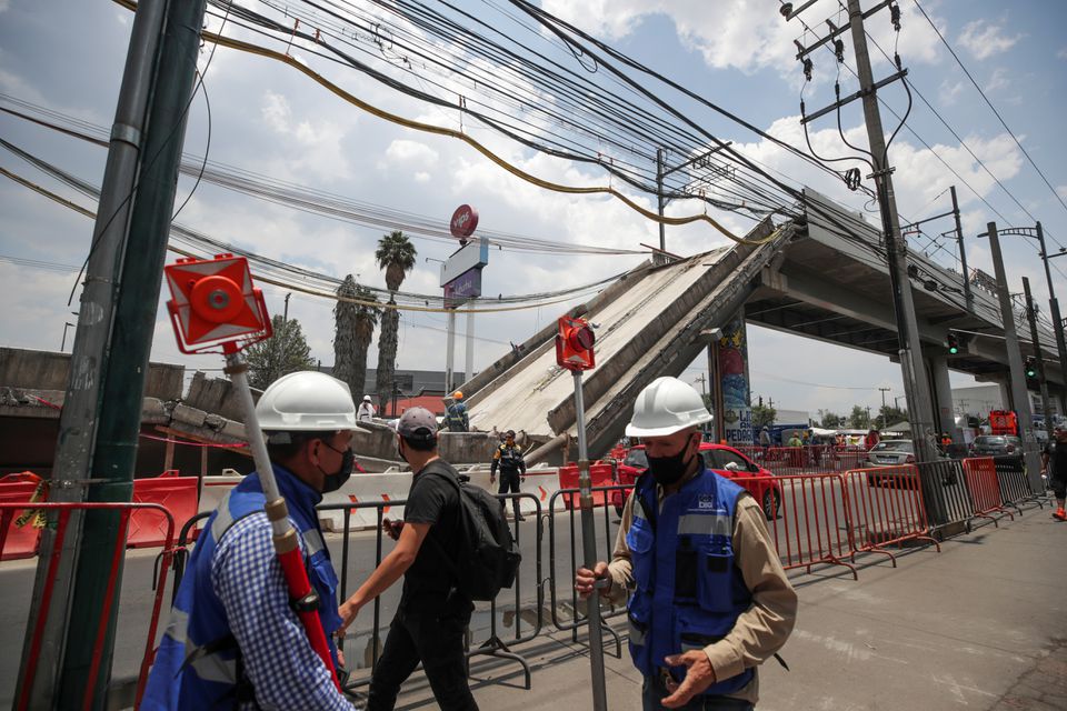 FILE PHOTO: Employees work as part of the investigations in front of the site where an overpass for a metro partially collapsed with train cars on it, in Mexico City, Mexico May 19, 2021. REUTERS/ Henry Romero/File Photo

