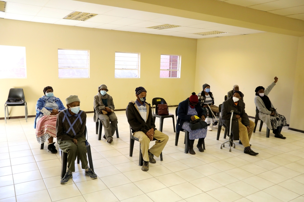 FILE PHOTO: People wearing protective masks sit ahead of a vaccination, as South Africa rolls out the coronavirus disease (COVID-19) vaccines to the elderly at the Munsieville Care for the Aged Centre outside Johannesburg, South Africa May 17, 2021. REUTE