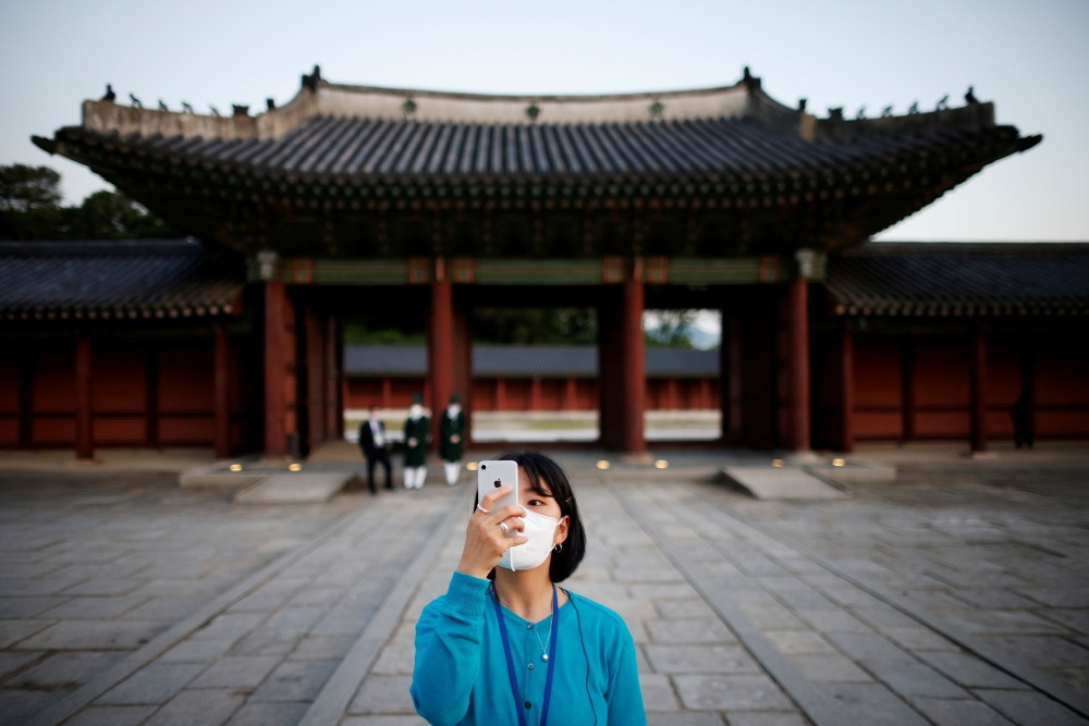 A woman takes photographs during a late-night admission which is offered for limited visitors amid the coronavirus (COVID-19) pandemic, at Changdeok Palace, in Seoul, South Korea, May 13, 2021. REUTERS/Kim Hong-Ji/File Photo