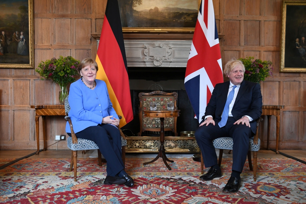 German Chancellor Angela Merkel poses with Britain's Prime Minister Boris Johnson before their bilateral meeting at Chequers, the official country residence of the Prime Minister, near Aylesbury, Buckinghamshire, Britain July 2, 2021. Stefan Rousseau/Pool
