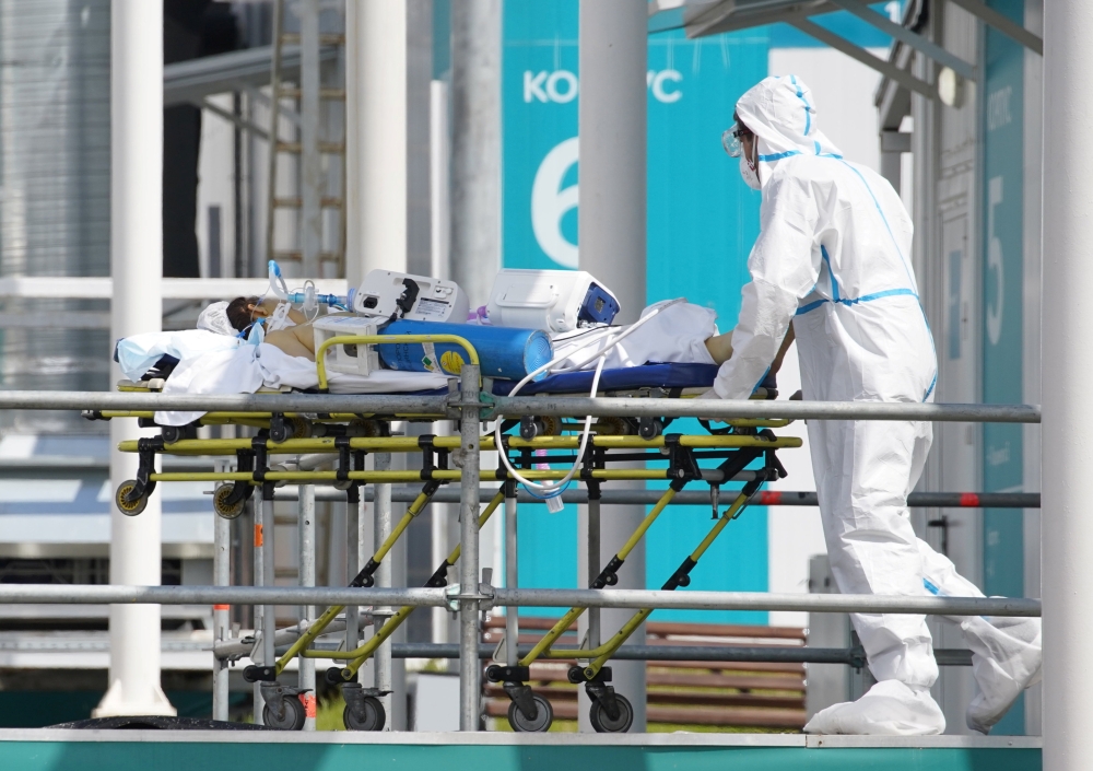 A medical specialist wearing protective gear transports a person on a stretcher at a hospital for patients infected with the coronavirus disease (COVID-19) on the outskirts of Moscow, Russia July 2, 2021. REUTERS/Tatyana Makeyeva