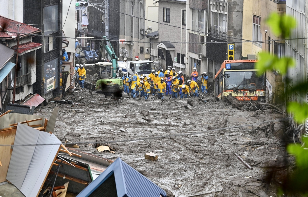 Police officers conduct search and rescue operation at a mudslide site caused by heavy rain at Izusan district in Atami, west of Tokyo, Japan July 4, 2021, in this photo taken by Kyodo. Kyodo/via REUTERS