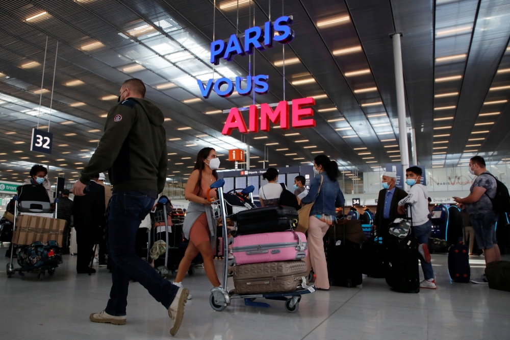 Passengers line up to check in inside the Terminal 3 at Orly Airport, near Paris, France, July 1, 2021. REUTERS/Sarah Meyssonnier