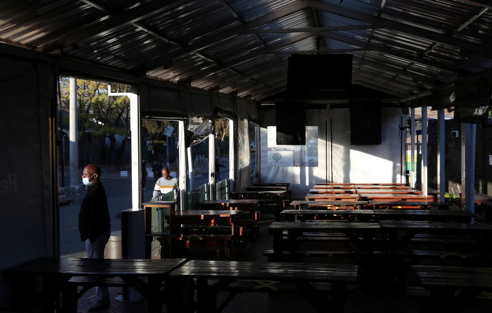 Empty seats are seen while a restaurant manager looks on during the coronavirus disease (COVID-19) outbreak as the country faces tougher lockdown restrictions in Soweto, South Africa, June 28, 2021. REUTERS/Siphiwe Sibeko
