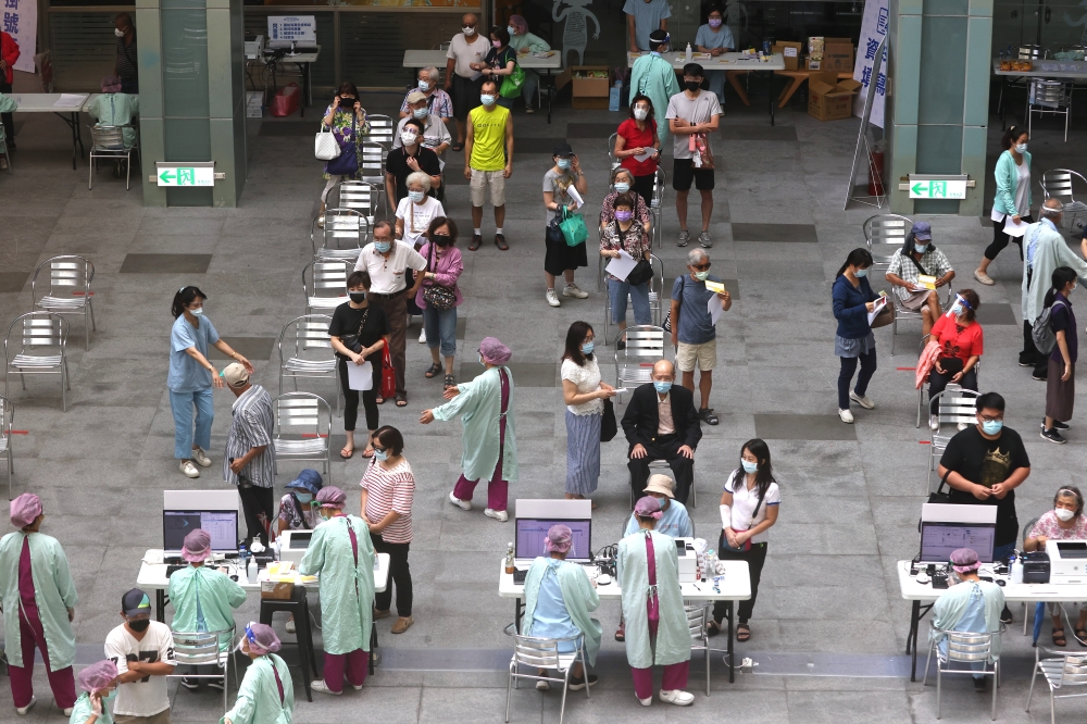 People wait to receive a dose of the Moderna vaccine against the coronavirus disease (COVID-19) at the National Taiwan Science Education Center in Taipei City, Taiwan July 3, 2021. REUTERS/Ann Wang