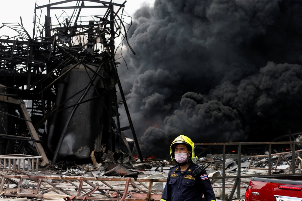 Emergency personnel looks on as smoke rises from a plastic factory after an explosion in Samut Prakan, outside Bangkok, Thailand July 5, 2021. REUTERS/Soe Zeya Tun